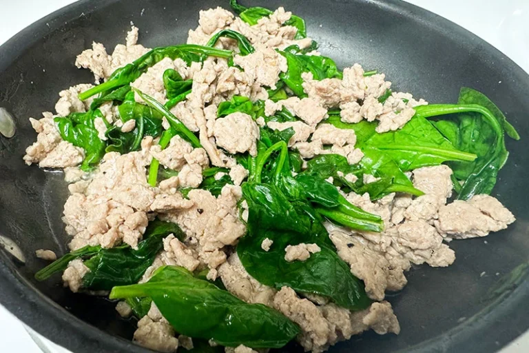 turkey and spinach cooked in skillet.