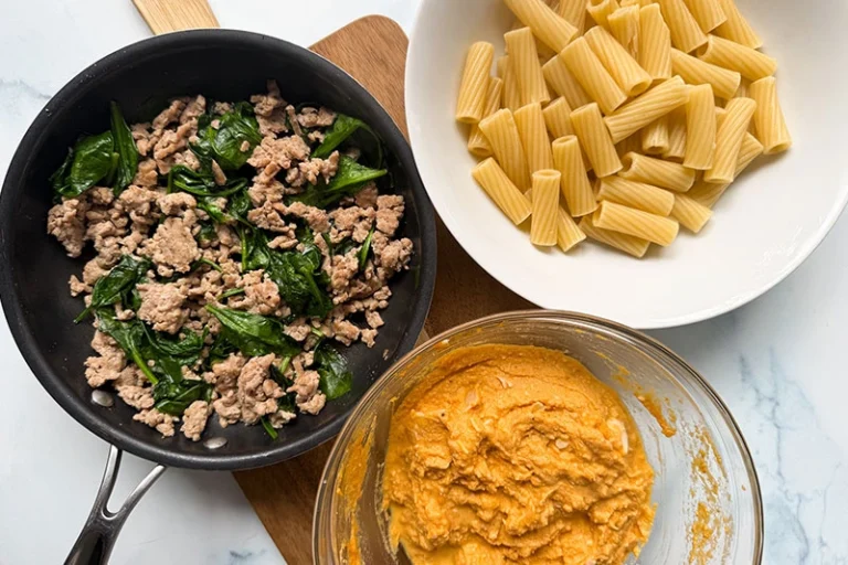 bowl of pasta,bowl of pumpkin sauce, and skillet of turkey and spinach.