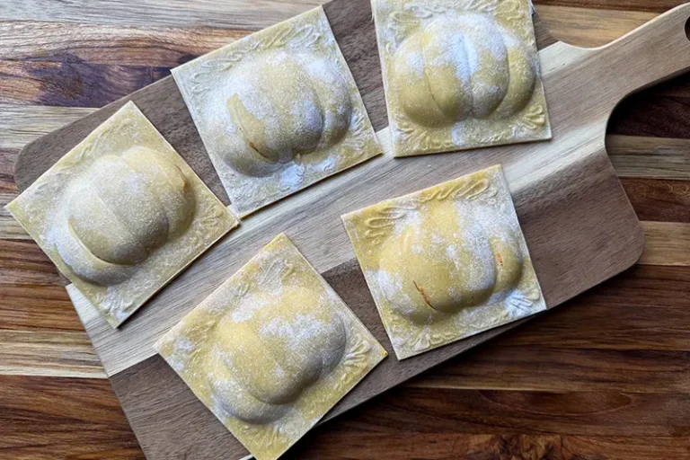 five cut ravioli on a cutting board.