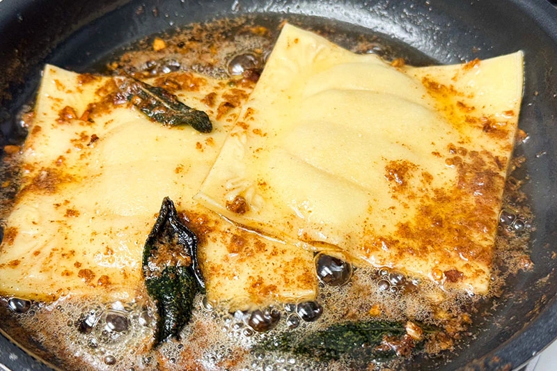 ravioli cooking in brown butter sauce.