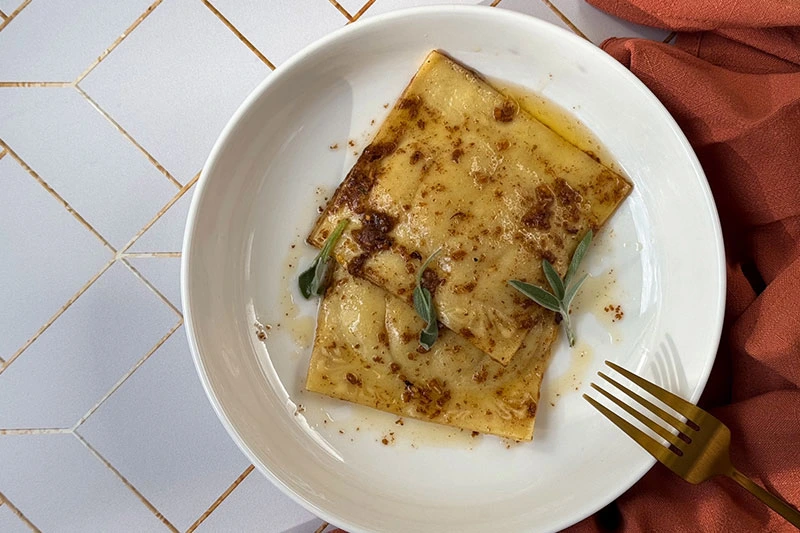 ravioli in a brown butter sauce with maple and sage.