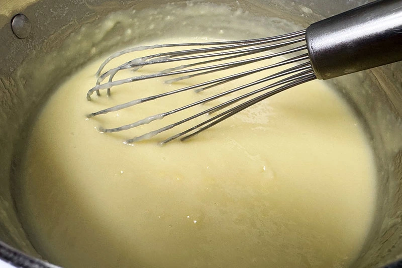 whisking coconut custard in pot.