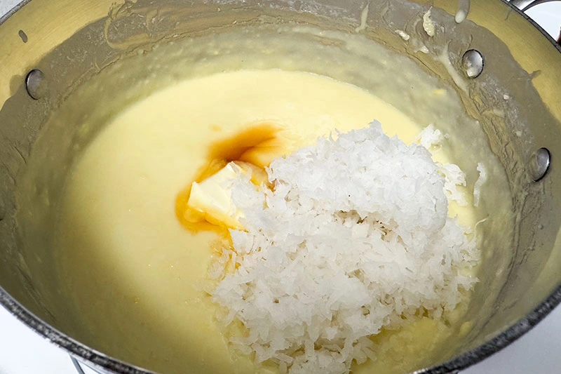 custard with extracts, butter and coconut in a pot.