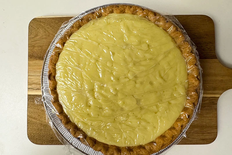 coconut custard pie wrapped in plastic wrap.