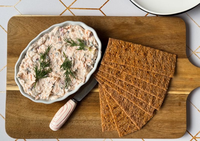 crock of salmon spread with crackers on a serving board.