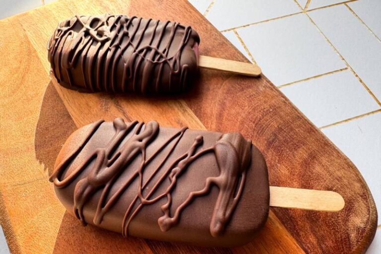 chocolate dipped yogurt pops on serving board.
