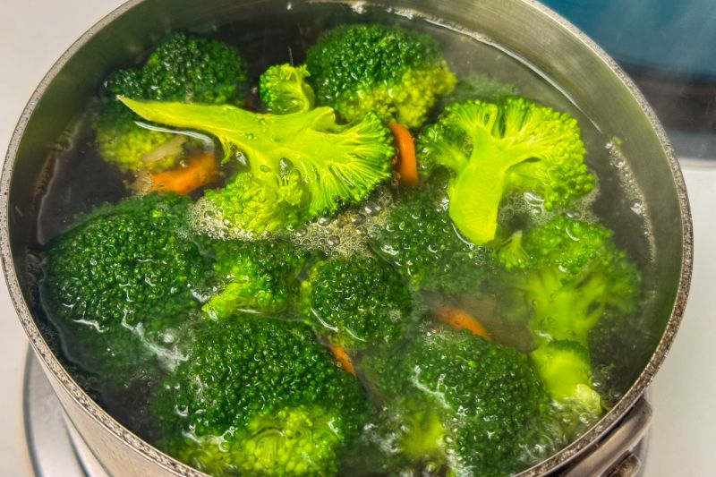 pot of boiling water with broccoli and carrots.