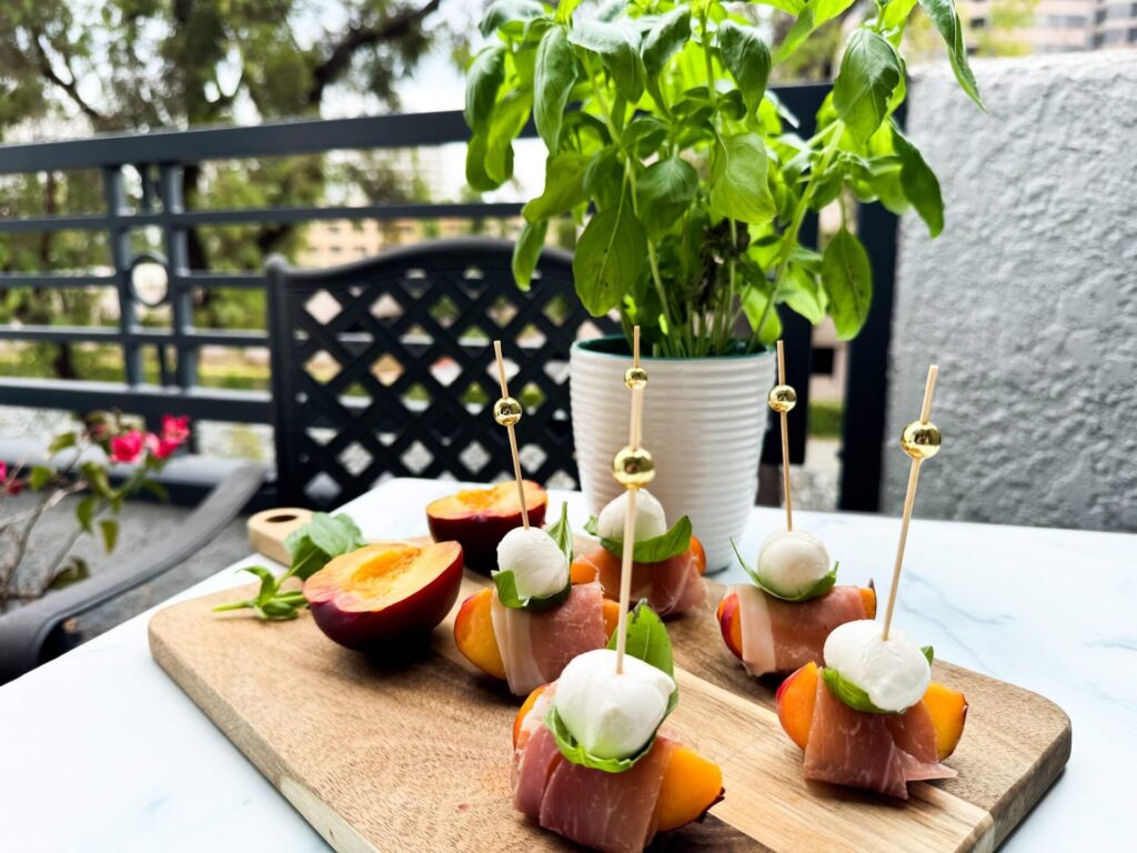 A wooden cutting board displaying an assortment of colorful fruits and various cheeses arranged artfully.