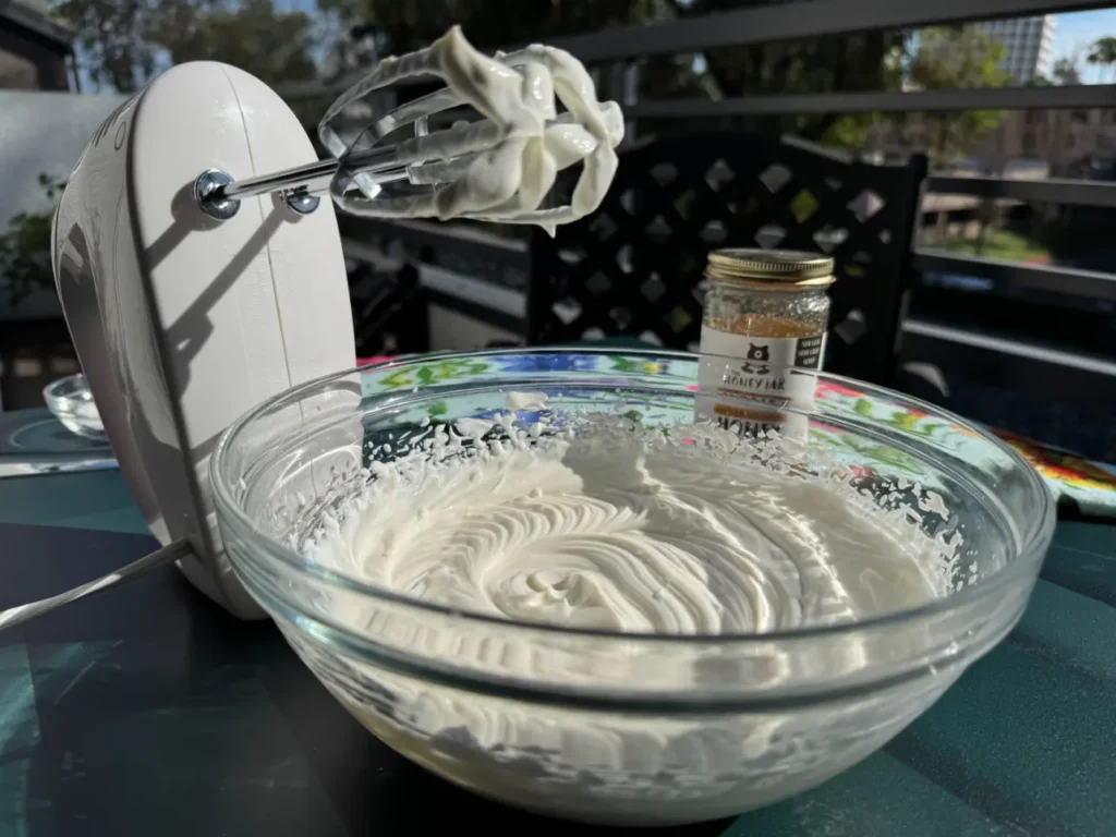 bowl of whipped cream with beaters.