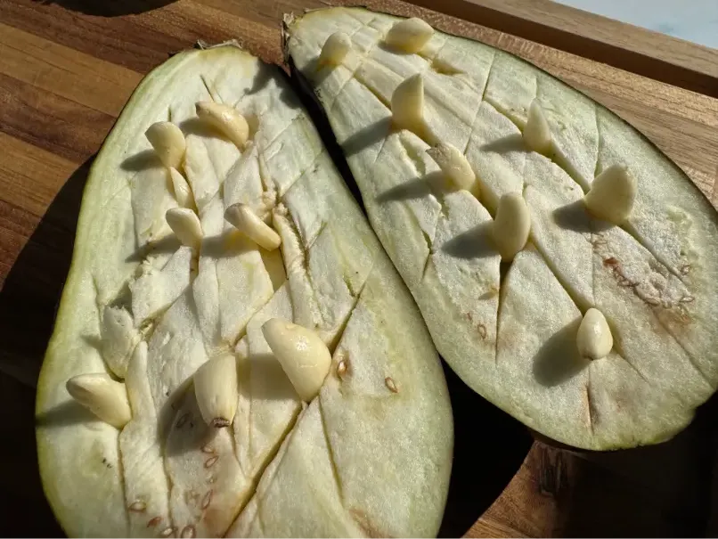 sliced eggplant with garlic cloves.