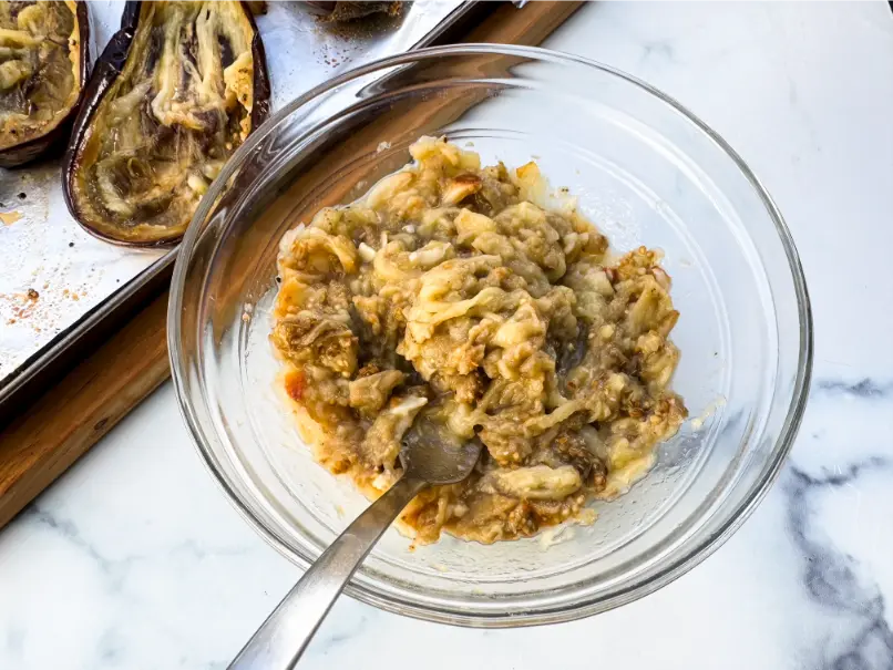 roasted eggplant and garlic smashed in bowl.