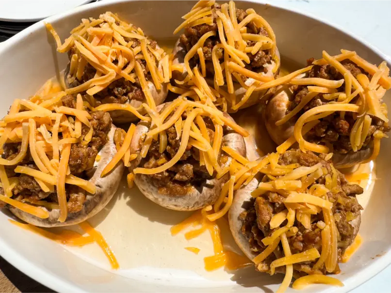 cheese on top of stuffed mushrooms.